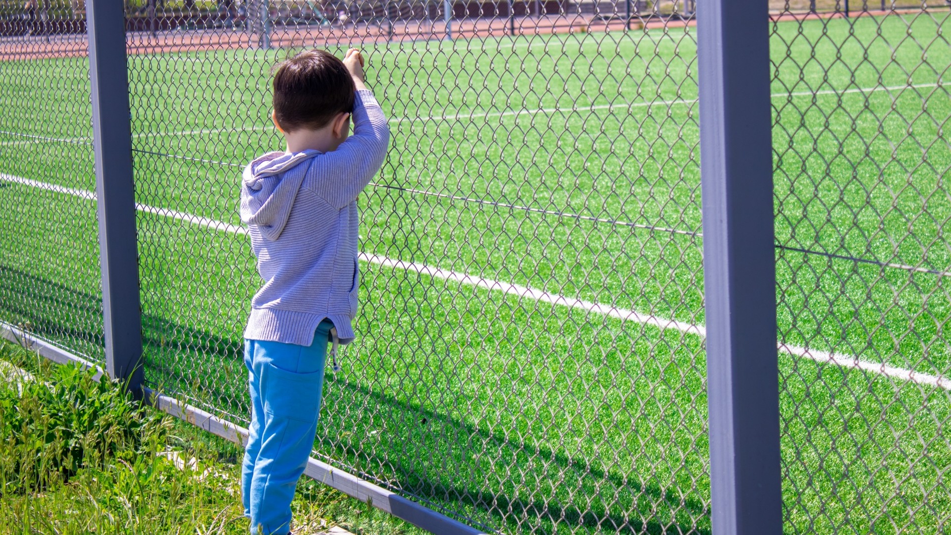 gamin seul devant terrain foot